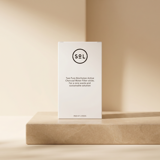 SoL charcoal water filter sticks box on a beige stone podium, warm minimalist studio