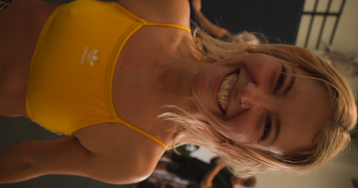 Woman wearing a yellow sports bra with a blurred background